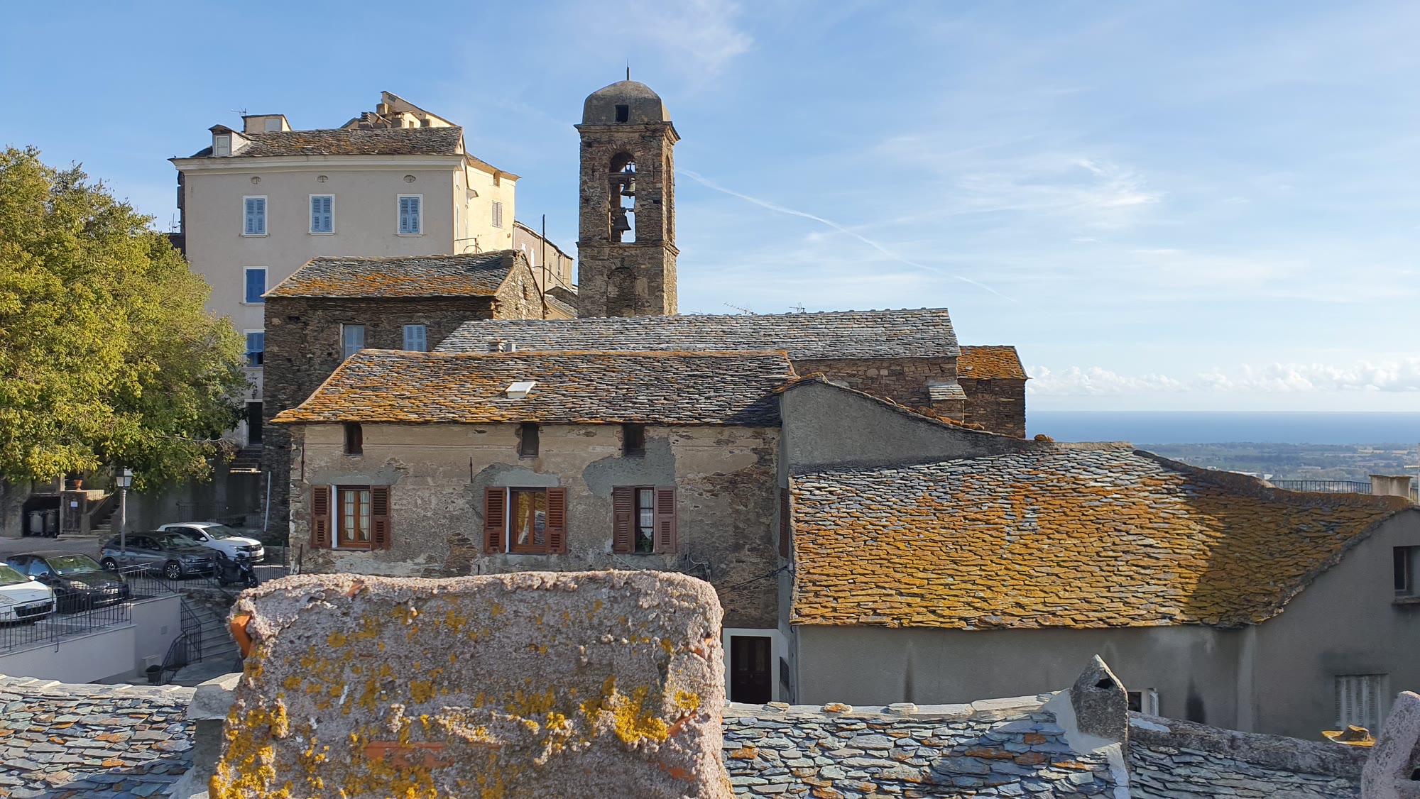 Toits de pierre et clocher d'un village de la côte orientale de la Haute-Corse, vus depuis une toiture